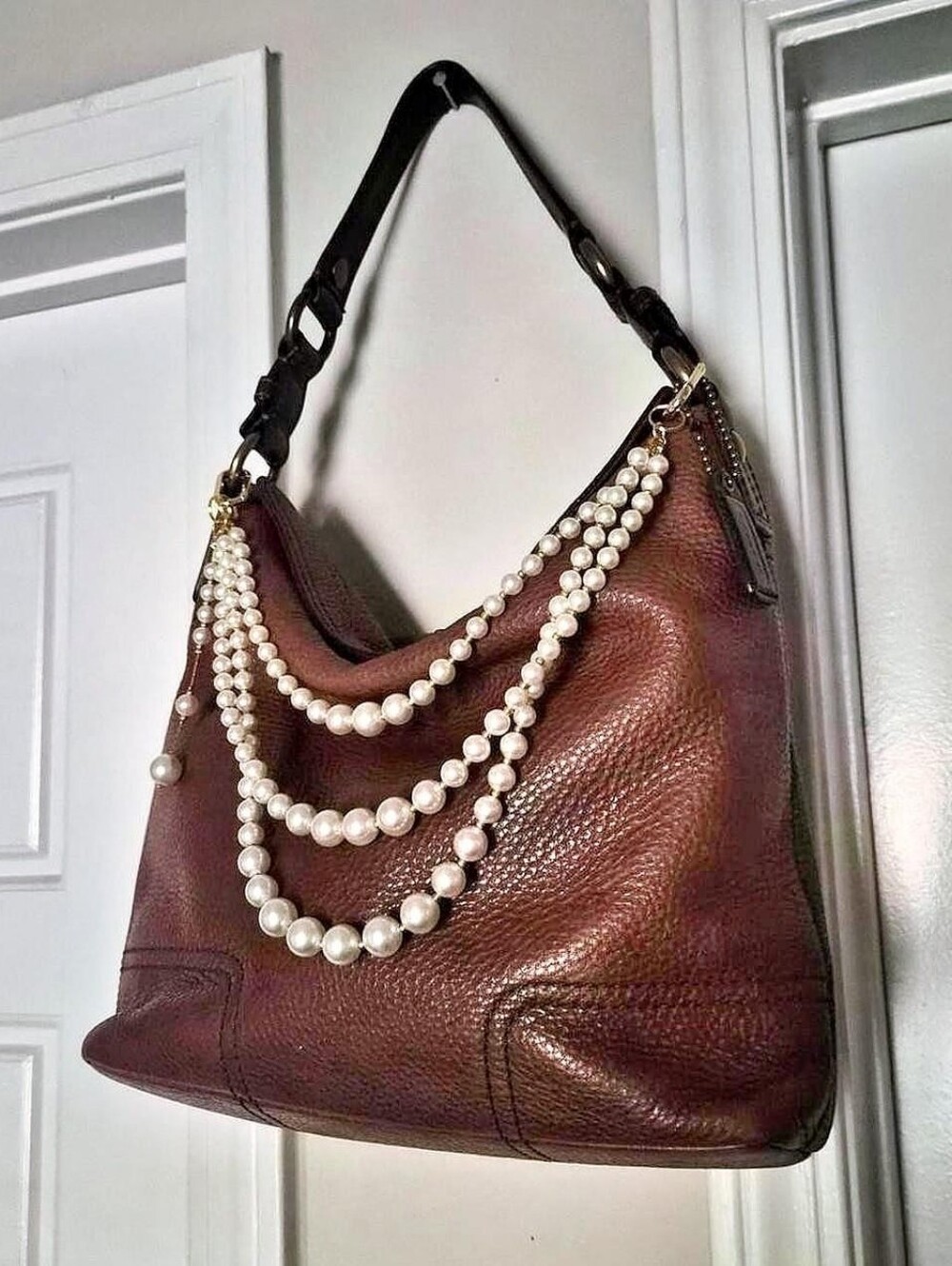 Coach Chelsea Slouchy Turnlock Hobo Bag with brass hardware and pearl bag charm.